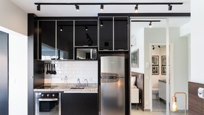 Eine moderne Küche mit Einbauofen, Edelstahlkühlschrank und einer Arbeitsplatte aus Granit.