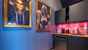 Une cuisine moderne équipée d’un lave-vaisselle, d’une machine à café et d’un élément décoratif aquatique illuminé de lumière rouge.