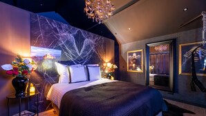 Une chambre moderne avec un grand lit, un mur en marbre et un lustre.