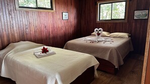 Two beds with white linens and a red flower, wooden walls, and framed pictures. - Campo Azul #3 - Monteverde (Provincia de Puntarenas)