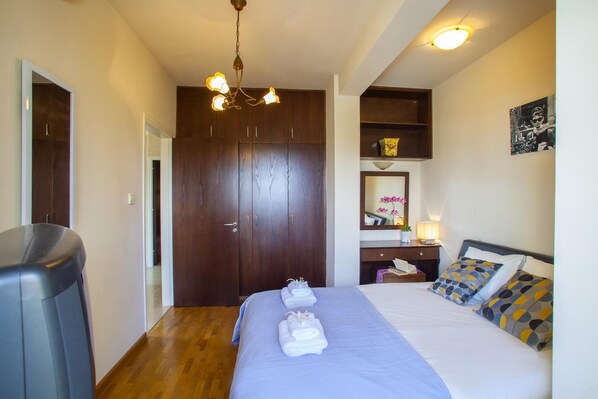 Quarto com cama, escrivaninha, cadeira, guarda-roupa e luz no teto.