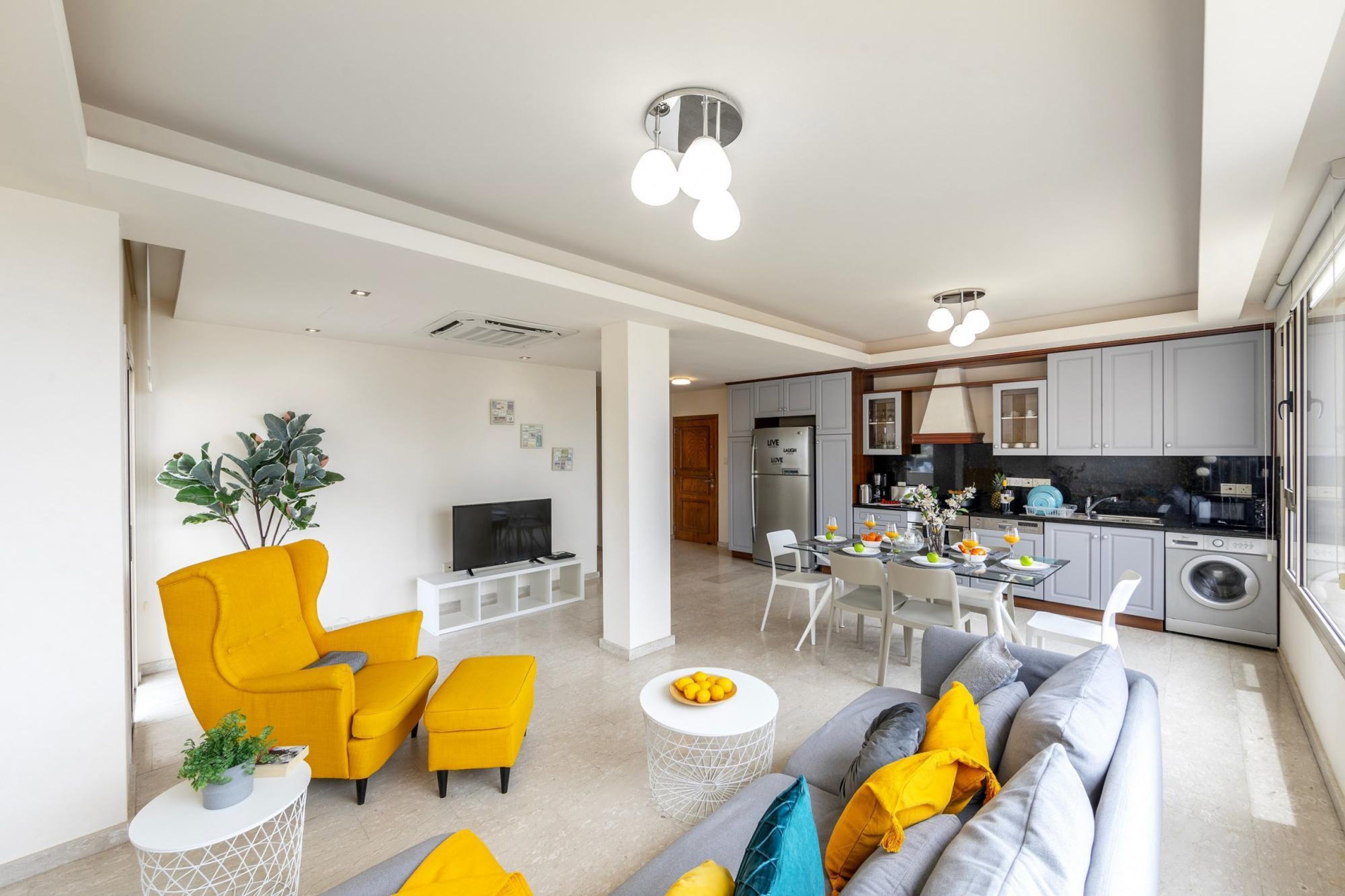 A modern apartment with a living room, dining area, and kitchen.