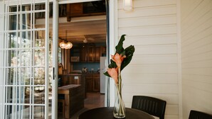 A dining area with a table, chairs, and a vase with flowers.