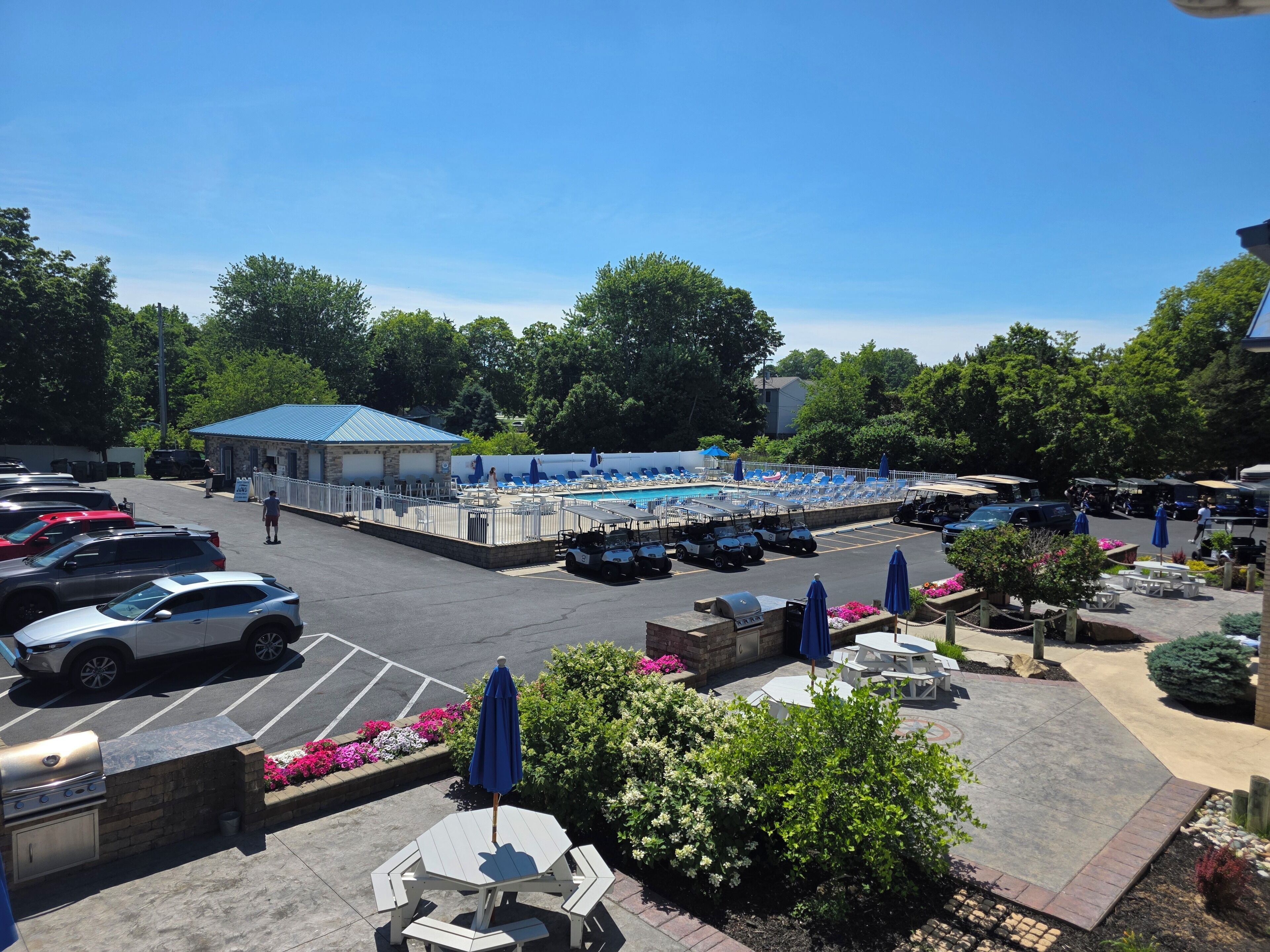 Un parking doté d’un espace piscine, d’un coin salon extérieur et d’un barbecue.