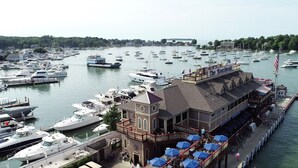 Un port de plaisance où sont amarrés de nombreux bateaux, un restaurant en bord de mer appelé « The Boardwalk », et une vue sur les environs.
