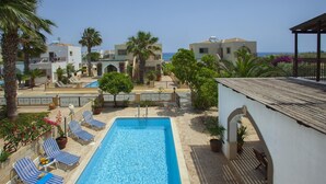 Une piscine avec des chaises longues et vue sur la mer.