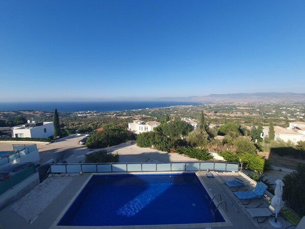 A rooftop pool with a clear view of the sea and surrounding landscape.