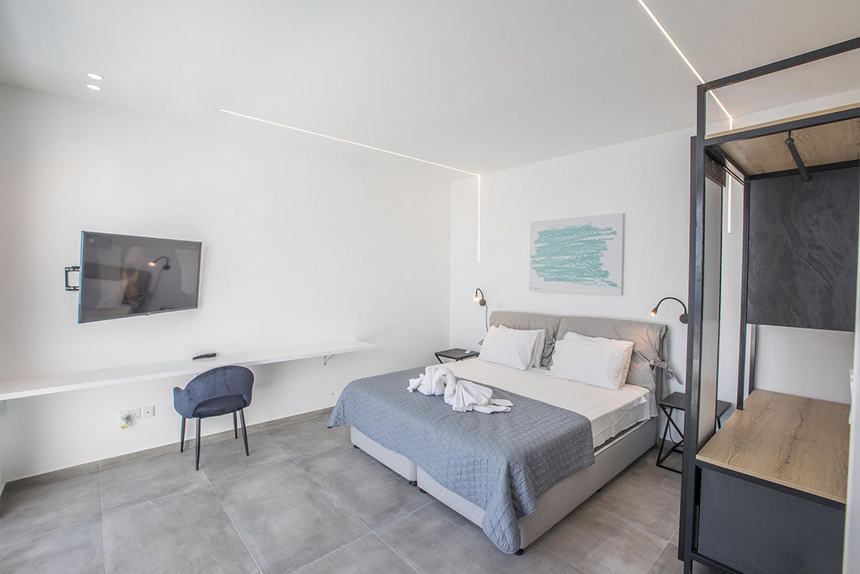 Ein modernes Schlafzimmer mit einem Bett, einem Schreibtisch und einem Stuhl.