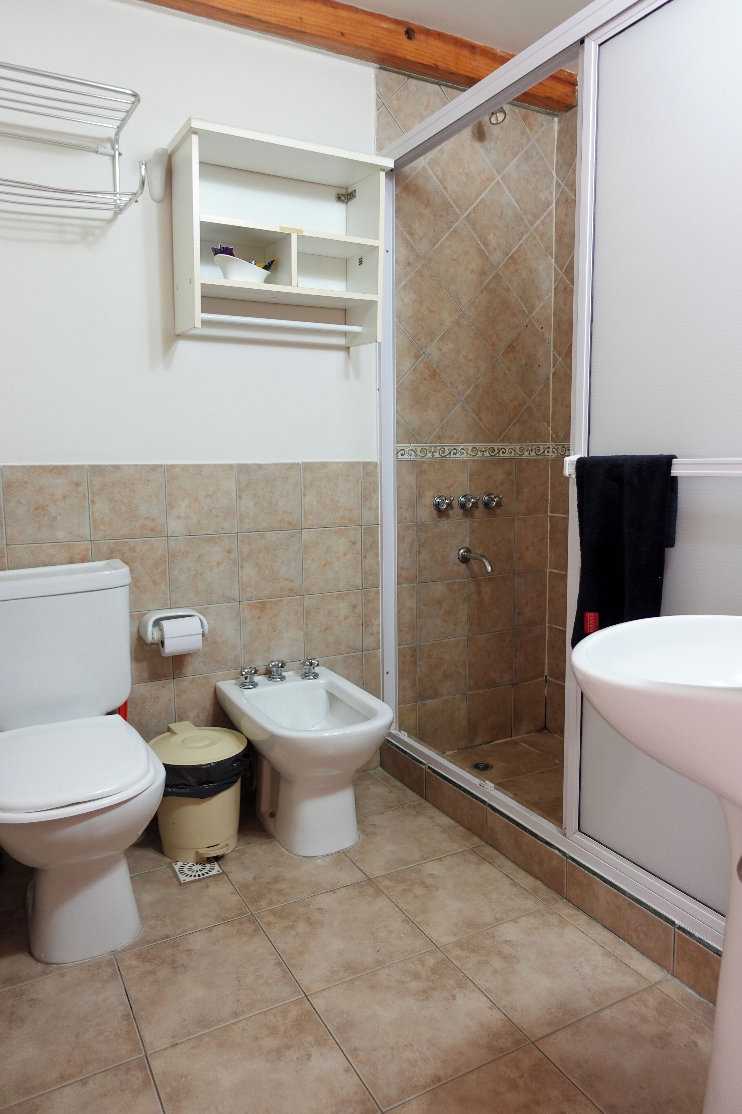 Ein Badezimmer mit Toilette, Bidet, Waschbecken und Dusche.