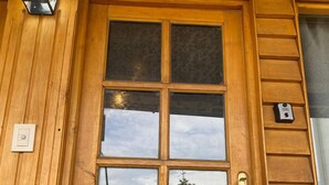 A wooden door with a number '5' above it, a glass panel, and a brass handle.