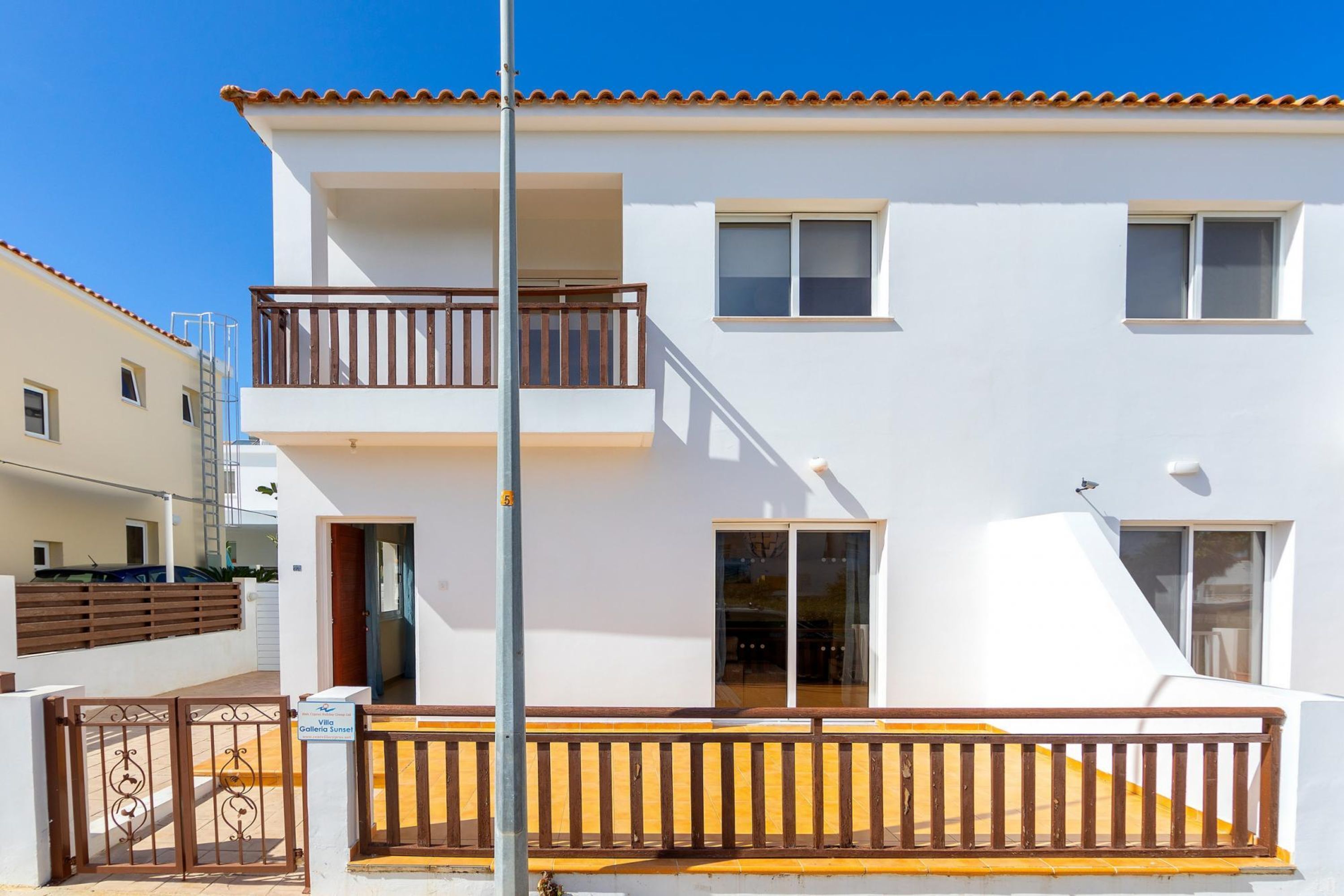 Un immeuble résidentiel de deux étages, doté d’un balcon à l’étage supérieur, d’une entrée sécurisée et surplombant un ciel dégagé.