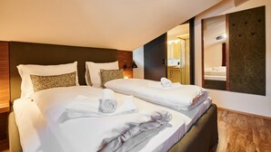 A hotel room with two beds, a large mirror, and a wooden headboard. - EVI Apartments - Valerie (Kaprun)