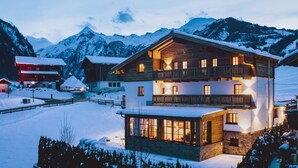 A two-story chalet with a balcony, surrounded by snow-covered mountains. - Chalet Evi in Kaprun (Kaprun)