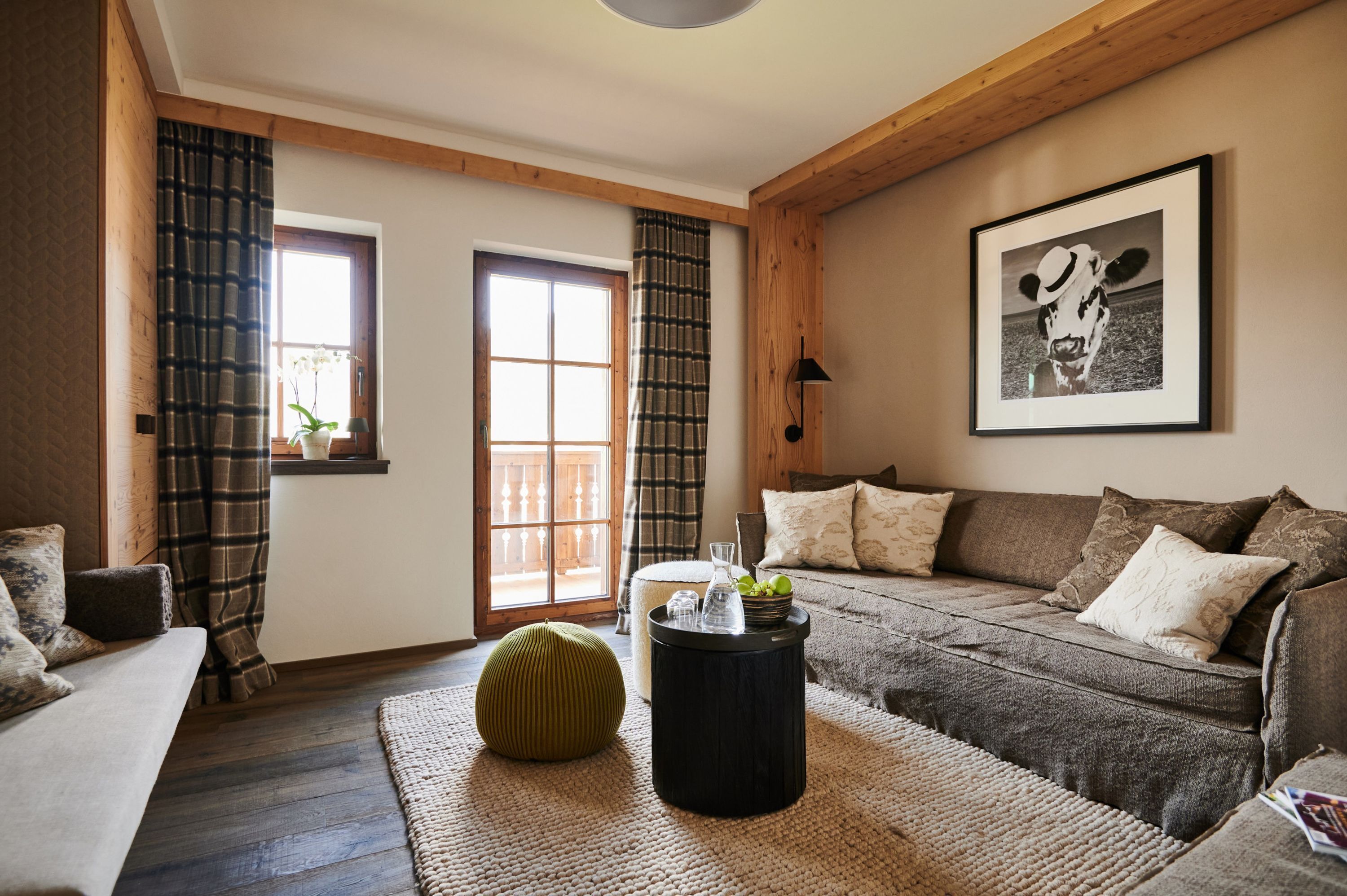 A cozy living room with a sofa, a round ottoman, a coffee table, and a framed picture on the wall.