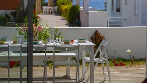 An outdoor dining area with white furniture and a view of the sea. - Protaras Villa Oceania (Paralimni)