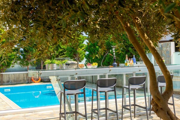 Ein Außenpoolbereich mit Bar und Sitzgelegenheiten.