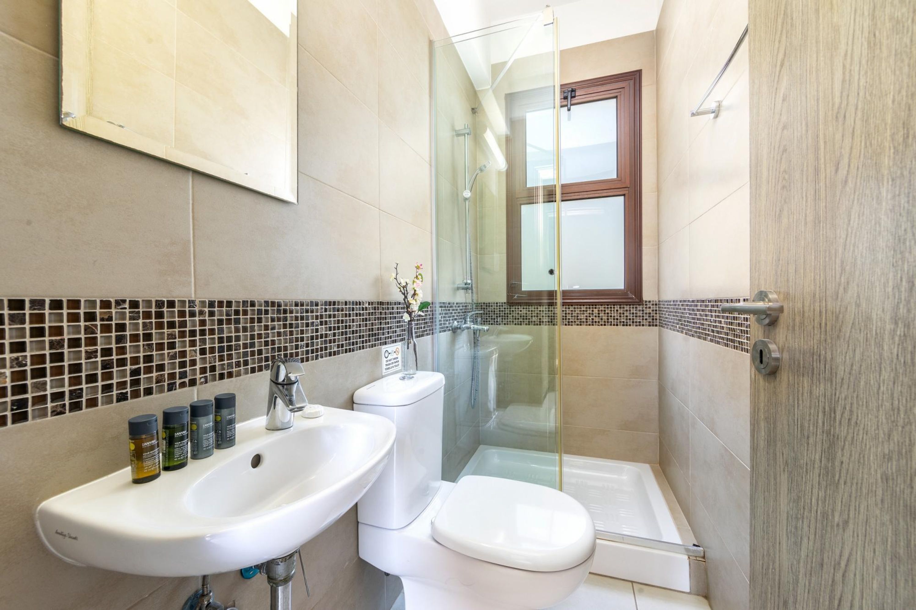 Een badkamer met een wastafel, toilet en een douchecabine.
