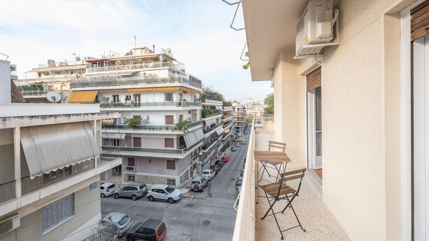 A residential building with multiple balconies, a street view, and parked cars. - Cozy and Fresh 2bdrm apt Close to Metro (Athens)