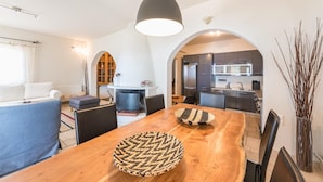 A modern living room with a wooden dining table, black chairs, and a hanging light fixture. - Voula Sea View Home With Jacuzzi Newly Refreshed 2026 (Vari-Voula-Vouliagmeni)