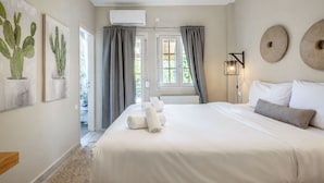 A bedroom with a bed, curtains, a wall-mounted lamp, and artwork. - Voula Sea View Home With Jacuzzi Newly Refreshed 2026 (Vari-Voula-Vouliagmeni)