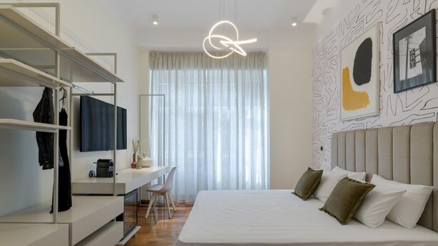 A modern bedroom with a bed, a desk, and a wardrobe. - An Outstanding 3 Bdrm Apartment in the Heart of Athens (Athens)