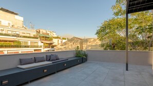 A rooftop terrace with a built-in seating area, a pergola, and a view of surrounding buildings and trees. - An Outstanding 3 Bdrm Apartment in the Heart of Athens (Athens)