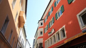 A narrow street with buildings featuring traditional European architecture, including a red building with a sign for 'Geschenke' and 'Gifts'. - Alpine City Living - TOP 13 (Zell am See)