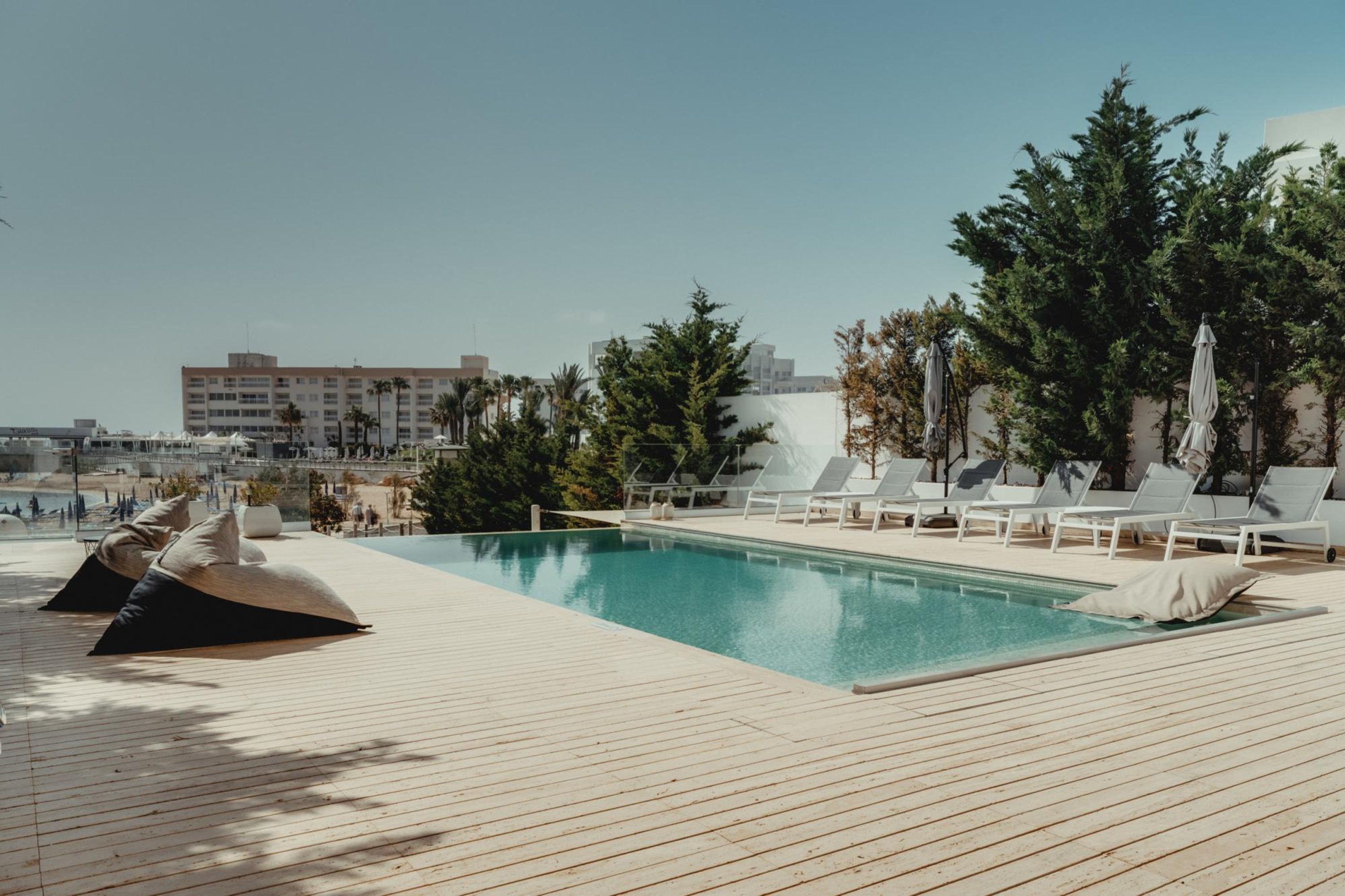 A pool area with lounge chairs and a wooden deck.