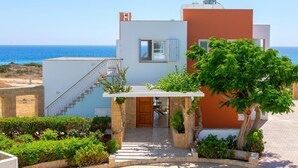 A modern two-story house with a balcony, a staircase, and a view of the sea. - Protaras Seafront Villa Violetta (Paralimni)