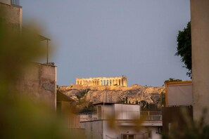 A view of the Acropolis in Athens, Greece, with the Parthenon prominently visible on the hill. - Fantastic Central Athens Suite With Rooftop Deck (Athens)