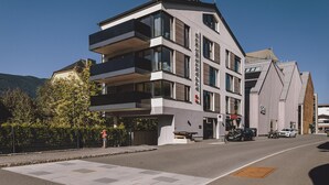 Een meerhoog gebouw met een modern architectonisch ontwerp, voorzien van balkons en grote ramen.