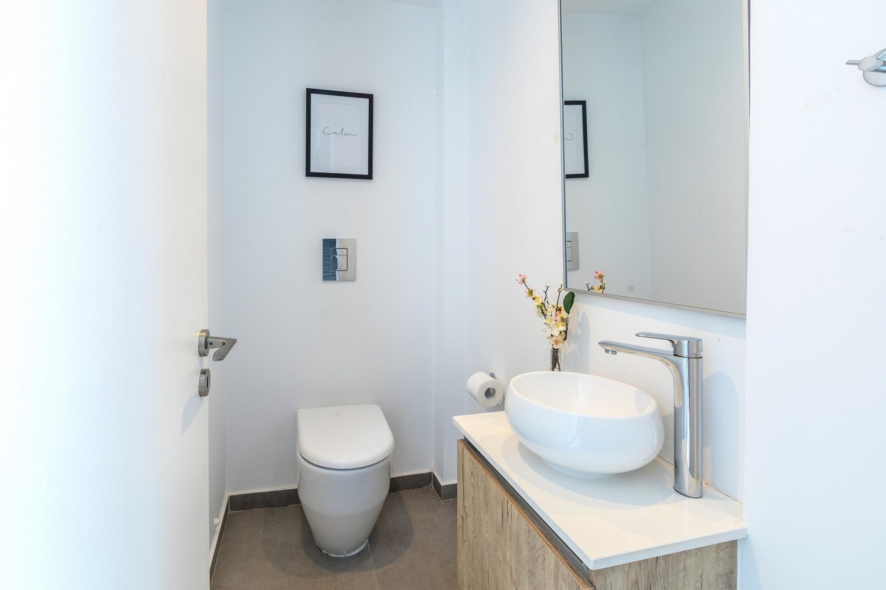 Une salle de bain moderne équipée de toilettes, d’un lavabo et d’un miroir.