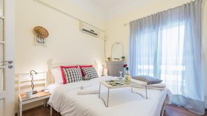 A bedroom with a large bed, bedside tables, a nightstand, a mirror, and a window with curtains. - Stylish 1BR Retreat in Central Athens (Athens)