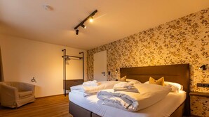 Ein Schlafzimmer mit Bett, einem Sessel, einem Kleiderschrank und einer Deckenleuchte.