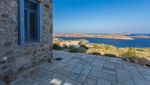 Un edificio de piedra con una ventana que da a un paisaje costero.