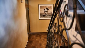 A staircase with a metal railing and a framed picture of a cow on the wall. - EVI Apartments - Evi (Kaprun)