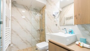 A modern bathroom with a glass-enclosed shower, a white toilet, and a wooden vanity with a sink. - Thissio Cocoon For Two (Athens)