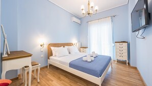 A bedroom with a bed, bedside tables, a desk, a chair, a dresser, and a TV. - Thissio Cocoon For Two (Athens)