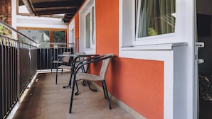 A balcony with chairs, a table, and a view of the outside. - Alpine City Living - TOP 31 (Zell am See)