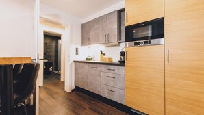 Een moderne keuken met houten kastjes, een Bosch magnetron en een spoelbak.