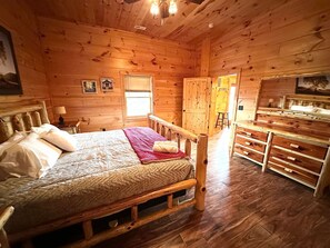 A wooden cabin interior with a bed, a dresser, and a window. - Private Large Mountaintop Cabin w/ wraparound deck (Dobson)