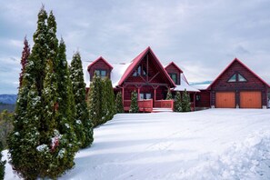 A large log cabin with multiple gabled roofs, a covered porch, and a snow-covered landscape. - Private Large Mountaintop Cabin w/ wraparound deck (Dobson)