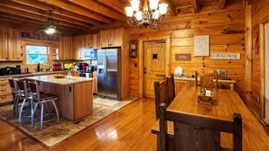 L’intérieur d’un chalet en bois comprend une cuisine, un coin repas et un panneau indiquant « Café et vin ».