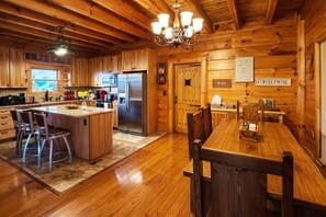 A wooden cabin interior with a kitchen, dining area, and a sign for 'Coffee & Wine'. - Private Large Mountaintop Cabin w/ wraparound deck (Dobson)