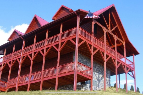 Una struttura in legno a più livelli con balconi, base in pietra e una bandiera americana.