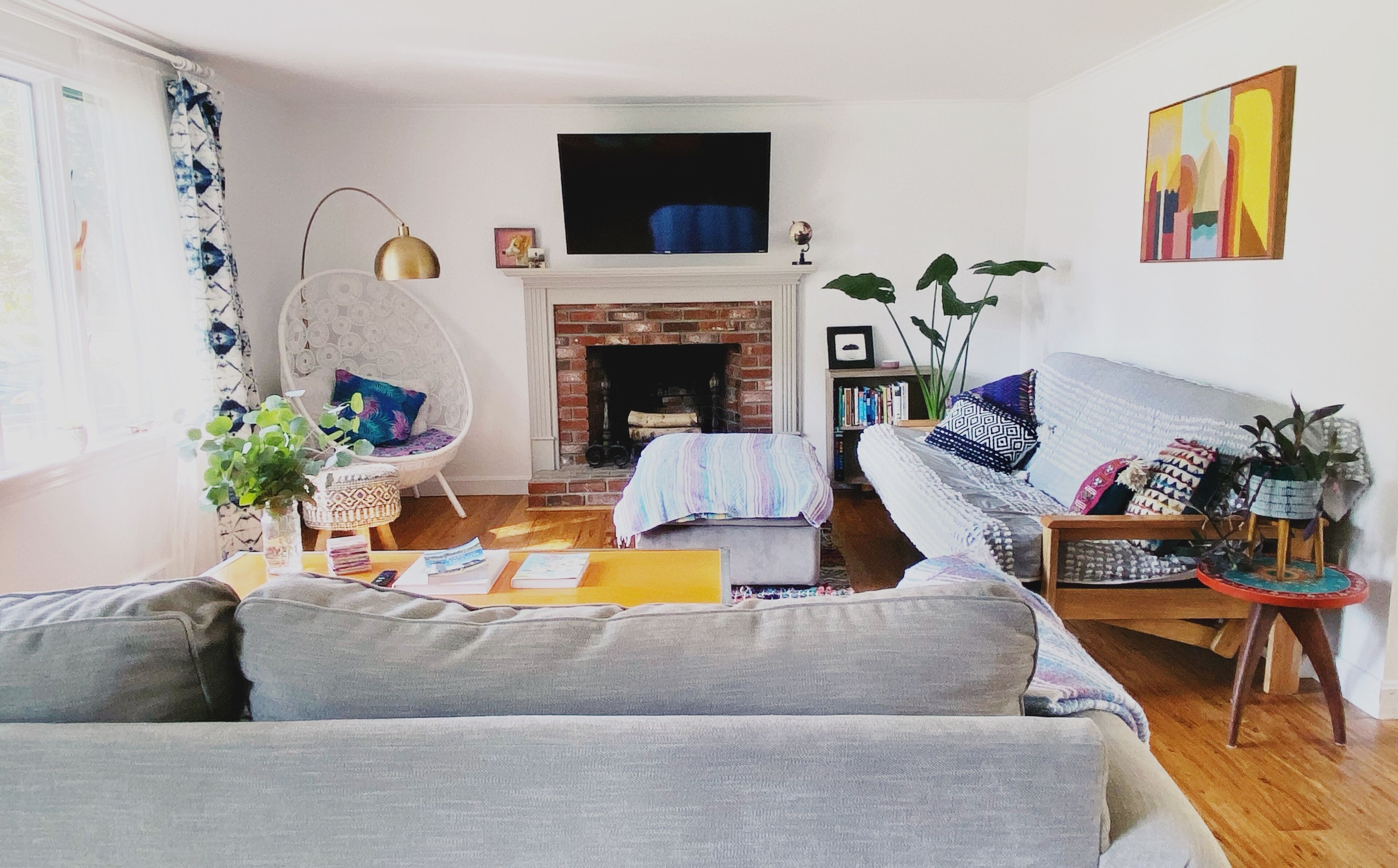 A living room with a fireplace, a sofa, a chair, and a bookshelf.
