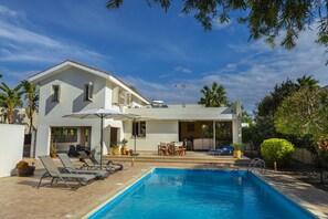 Relax in a pool area surrounded by lush greenery and palm trees.