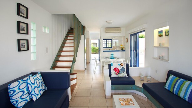 A modern living room with a staircase, a dining area, and a kitchen. - Villa Julie in Protaras (Paralimni)