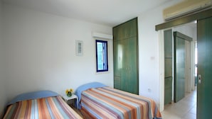 A room with two beds, a window, and a wardrobe. - Villa Julie in Protaras (Paralimni)