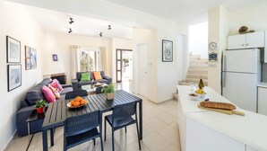 A modern apartment with a dining area, kitchen, and living room. - Cape Greco Palm Trees Villa (Ayia Napa)